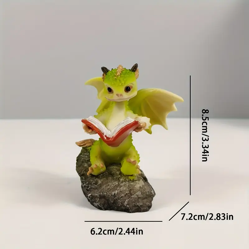 A cute green dragon figurine sitting on a rock, holding an open book, measuring 8.5 cm tall and 6.2 cm wide.