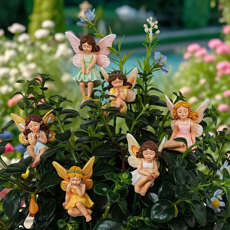 A charming arrangement of colorful fairy figurines perched among lush green foliage, creating a whimsical garden atmosphere.